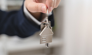 A landlord holding house keys up