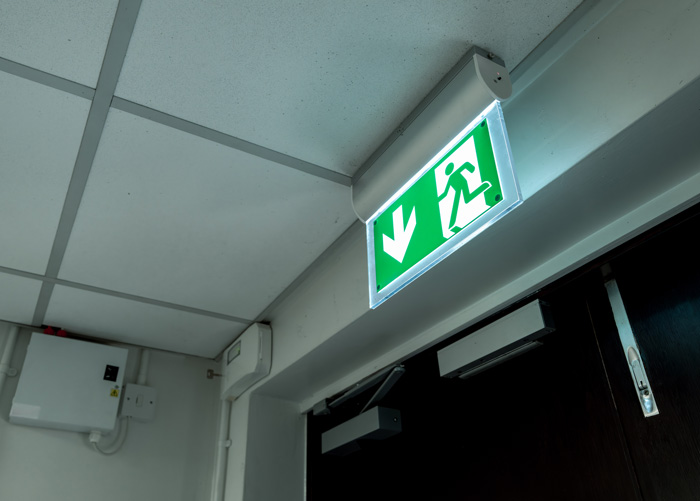 A fire exit sign by a fire door