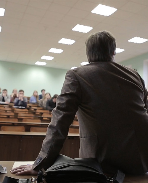 A speaker presenting to an audience in a lecture hall.