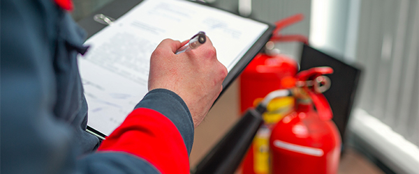 A man inspecting fire extinguishers