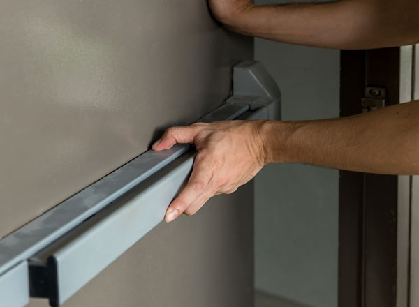 A man opening a fire door