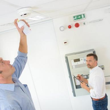 A man testing a fire alarm